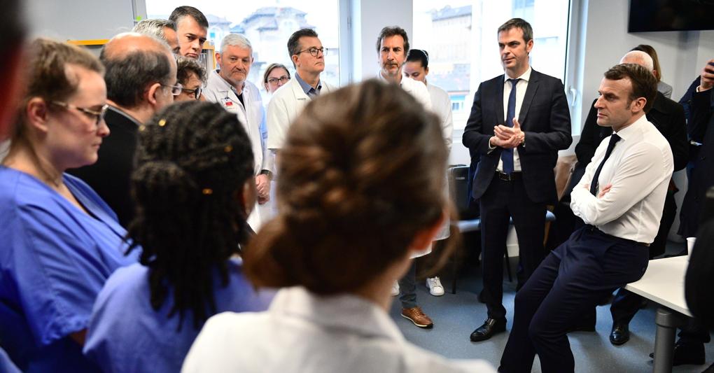 Emmanuel Macron e il ministro della Sanità, Olivier Veran (alla sua destra) con l’équipe medica dell’Hôpital de la Pitié Salpêtrière  