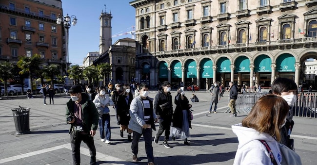 Persone con mascherine protettive per emergenza Coronavirus a Milano (Ansa)