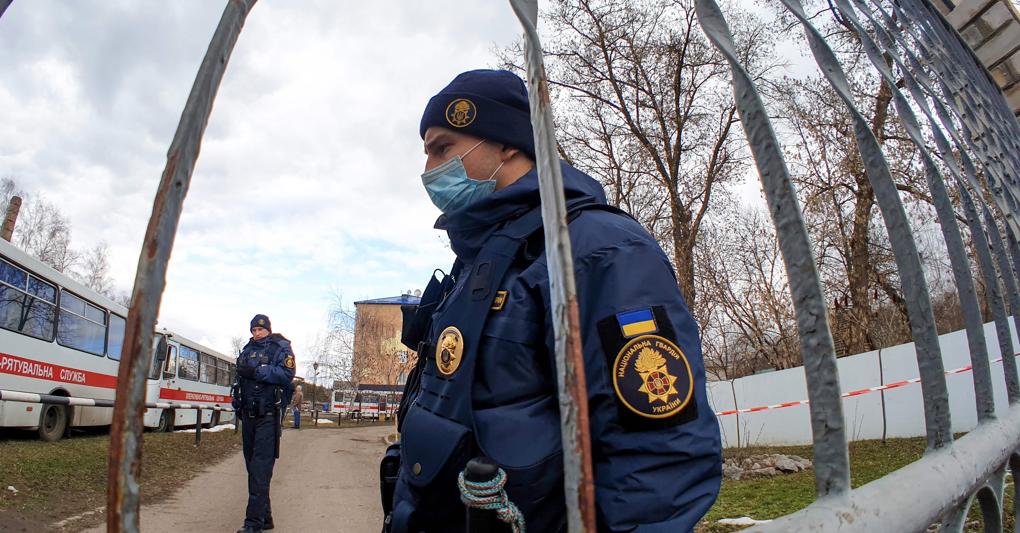 Militari della Guardia Nazionale ucraina sorvegliano il cancello della struttura che ospita in quarantena gli sfollati provenienti dalla Cina (Foto Str/Afp) 