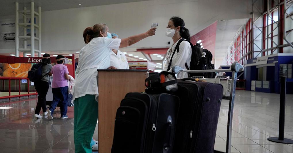 Una viaggiatrice si fa controllare la temperatura all'aeroporto internazionale Jose Marti a L'Avana, Cuba (Foto Reuters/Meneghini) 