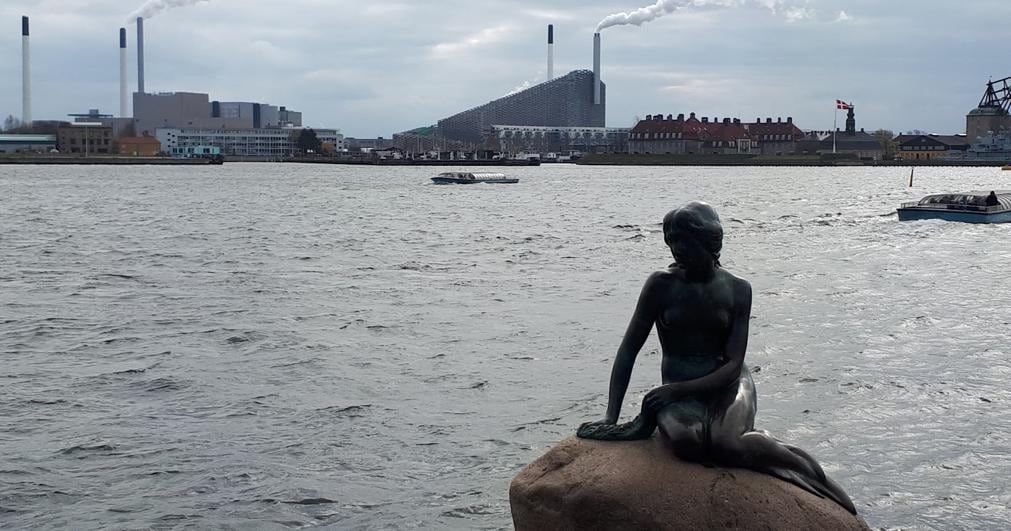  La statua della Sirenetta, uno dei simboli della capitale danese, con sullo sfondo il nuovo termovalorizzatore   