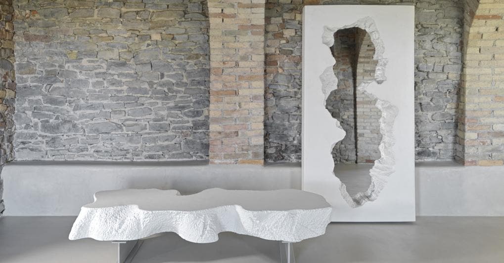 La Broken Bench di Gufram firmata da Daniel Arsham e Alex Mustonen: due piedini simili a putrelle da cantiere sostengono una lastra frastagliata di poliuretano rivestito con una vernice speciale 