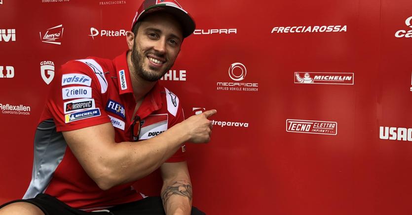 Andrea Dovizioso, pilota del team Ducati, indica il logo di MegaRide, la startup che esalta gli pneumatici