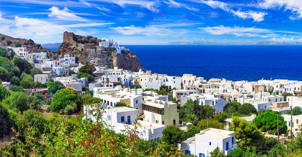 Mandráki. Il porto di Nisyros sovrastato dal  monastero di Moní Panagías Spillanís e da Paleókastro (Adobe Stock) 