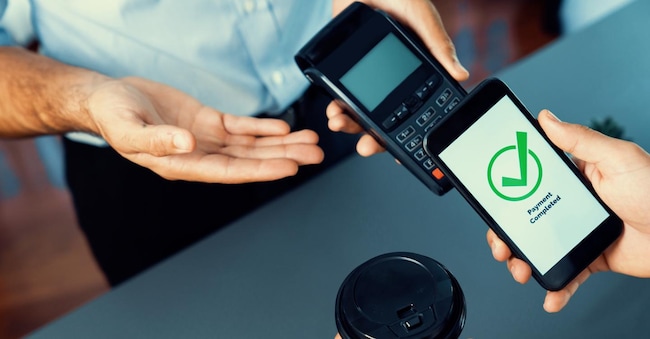 Hand holding smartphone with NFC QR code device, scanning contactless payment code for fast digital transaction. Online banking app on mobile phone for modern lifestyle payment technology. fervent