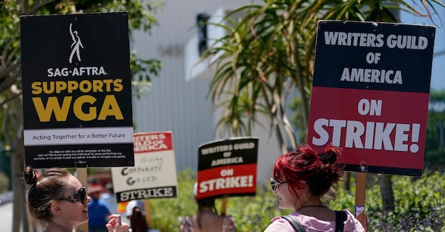 Picketers celebrate outside Netflix during a Writers Guild rally as a strike by The Screen Actors Guild-American Federation of Television and Radio Artists is announced on Thursday, July 13, 2023, in Los Angeles. This marks the first time since 1960 that actors and writers will picket film and television productions at the same time. (AP Photo/Mark J. Terrill)