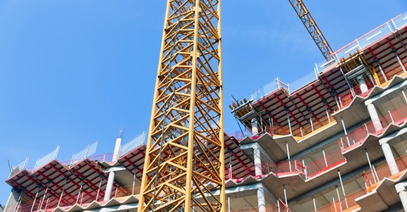 Construction site of apartment building with big yellow crane and blue sky