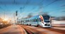 High speed train arrives on the railway station at sunset. Modern intercity train in motion on the railway platform. Passenger train on railroad with motion blur effect. Railway transportation