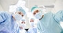 surgery, medicine and people concept - group of surgeons in operating room at hospital looking into camera