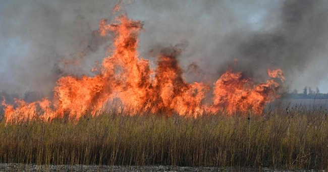 Fiamme nel villaggio di Grakovo, nella regione di Kharkiv, dopo un attacco russo (Photo by SERGEY BOBOK / AFP)