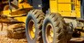 Road grader working at construction site for maintenance and construction of dirts and gravel road. Yellow motor grader. Heavy machinery and construction equipment for grading roads. Grader machine.