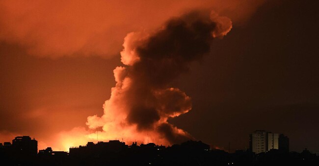 Fuoco e fumo sopra gli edifici di Gaza durante un raid di Israele