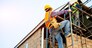 Construction worker wearing safety harness and safety line working at high place.
