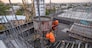 The workers on a building infrastructure roof with machinery and tools. Pouring concrete into a mold