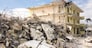The last standing section of a hotel in the final stages of demolition with a large pile of jumbled concrete, steel rebar, and other debris in front waiting to be hauled away.