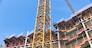 Construction site of apartment building with big yellow crane and blue sky