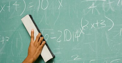 Person removing formulas from the blackboard