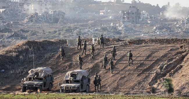 Un’immagine scattata nel sud di Israele, vicino al confine con la Striscia di Gaza, l’11 dicembre 2023, mostra i soldati dell’esercito israeliano che prendono posizione su una collina che domina il nord di Gaza, in mezzo ai continui combattimenti tra Israele e il gruppo militante Hamas. (Foto di Menahem KAHANA / AFP)