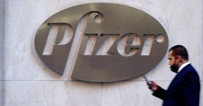 FILE PHOTO: A person walks past the Pfizer Headquarters building in the Manhattan borough of New York City, New York, U.S., November 9, 2020. REUTERS/Carlo Allegri/File Photo