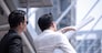 Asian businessman discuss with engineer architect in suite, looking and point to finger forward away and holding construction roll plan for working team concept,back view