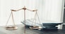 Shiny golden balanced scale and pile of legal paper on desk in lawyer office as concept justice and legal symbol. Scale balance for righteous and equality judgment by lawyer and attorney. equility