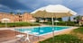 a beautiful and luxurious tuscany swimming pool with parasols and chairs