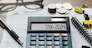 Word Tax 2024 on the calculator. Business and tax concept.Calculator, coins, book, tax form, and pen on table.Tax deduction planning.Financial research, government taxes, and calculation tax return