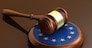 European Union laws, legal system and parliament concept with a 3d render of a gavel on a wooden desktop and the EU flag.