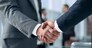 closeup of handshake of business partners on the background of business team