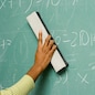 Person removing formulas from the blackboard