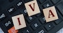 IVA (Individual Voluntary Arrangement) - acronym on wooden cubes on the background of a calculator. Business concept