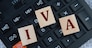 IVA (Individual Voluntary Arrangement) - acronym on wooden cubes on the background of a calculator. Business concept