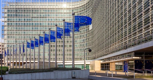 BRUSSELS, BELGIUM - JUL 30, 2014: Row of EU Flags in front of the European Union Commission building in Brussels.
