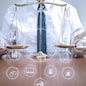 justice and law concept.Male lawyer in the office with brass scale on wooden table,virtual graphic icons screen diagram