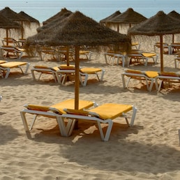 umbrellas on a sunny beach resort at algarve, portugal