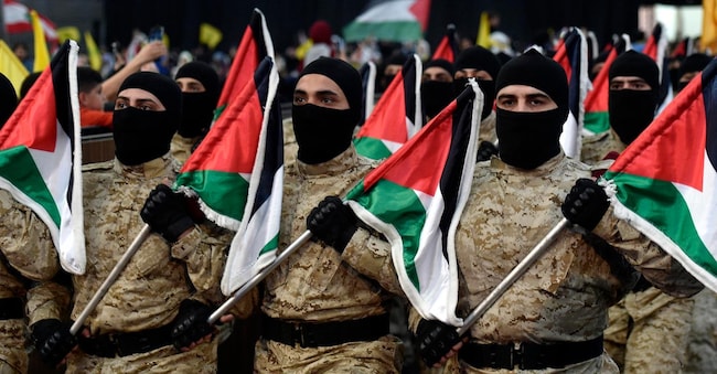 Membri di Hezbollah sfilano con bandiere libanesi al raduno per commemorare il giorno di Al Quds (giorno di Gerusalemme) in un sobborgo di Beirut