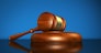 Law, justice and legal system concept with a wooden gavel judge symbol on blue background.