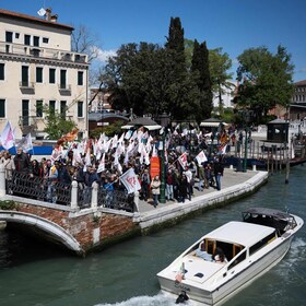 Protestors hold banners and flags as they take part in a demonstration against the new "Venice Access Fee", organised by the list "Tutta la citta’ insieme" (The whole city together) and members of several Venetians trade associations in "Piazzale Roma" in Venice, on April 25, 2024. Venice launched a new scheme to charge day-trippers for entering the historic Italian city, a world first intended to ease the pressure of mass tourism , but many residents are opposed, in Venice, on April 25, 2024. (Photo by MARCO BERTORELLO / AFP)