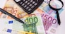 different euro banknotes, calculator, magnifier and pen. Financial concept.