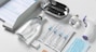 medicine and healthcare concept - close up of syringes, mask, hand sanitizer and other medical stuff on table at hospital