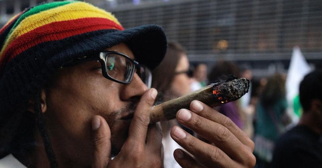 Un manifestante fuma cannabis alla 17esima Marcia della marijuana a San Paolo, in Brasile, il 16 June 2024 (EPA/Isaac Fontana)