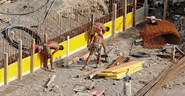 Alcuni lavoratori in un cantiere (Adobe Stock)