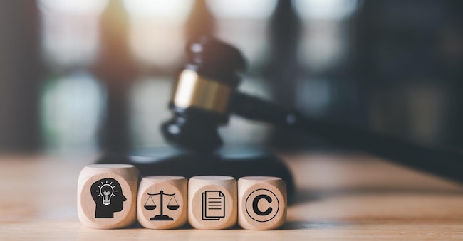wooden blocks and Wooden judge gavel on the table, concept of copyright or intellectual property patent protection of copyright infringement proprietary declaration Legitimate innovations