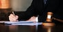 Legal counsel presents to the client a signed contract with gavel and legal law. justice and lawyer concept