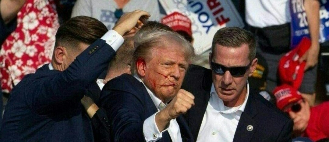 Republican candidate Donald Trump is seen with what appears to be blood on his face surrounded by secret service agents as he is taken off the stage at a campaign event at Butler Farm Show Inc. in Butler, Pennsylvania, July 13, 2024. (Photo by Rebecca DROKE / AFP)