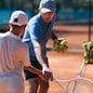 Tennis instructor with young boy in tennis training lesson
