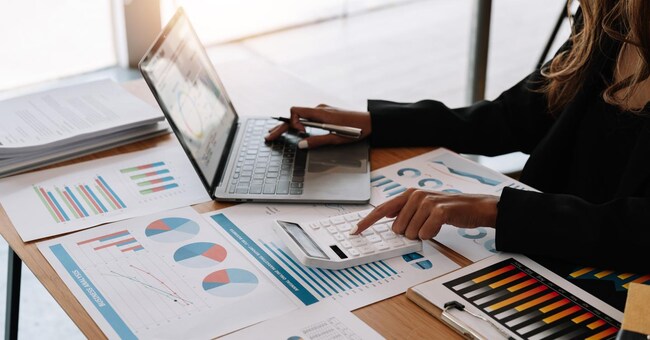 Close up view of bookkeeper or financial inspector hands making report, calculating or checking balance. Home finances, investment, economy, saving money or insurance concept.