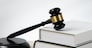 Closeup wooden gavel hammer and law book in empty law firm or white lawyer office background as justice and legal system by lawyer and judge, Legal authority and fairness in trial concept. equility