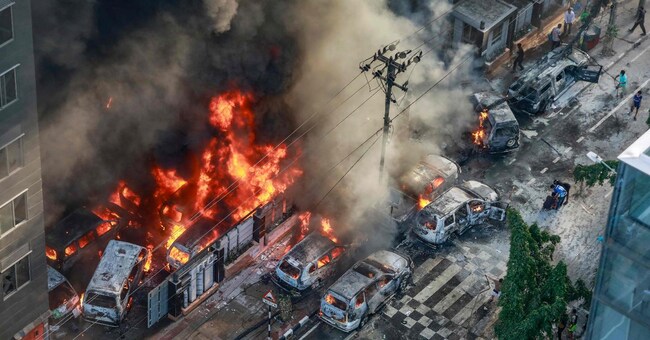 Veicoli date alle fiamme nelle strade di Dacca durante le manifestazioni studentesche contro il governo
