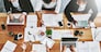 Overhead of colleagues having a marketing meeting in modern office. Above a busy workplace, coworkers brainstorm and develop strategies for a startup business, unity, planning and innovation at work.